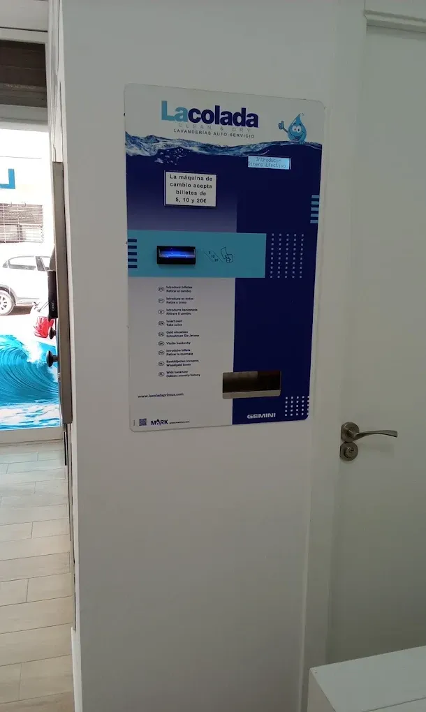 Panel de control de la lavadora de la lavandería montado en la pared junto a una puerta