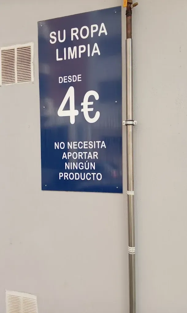 Cartel en español que ofrece ropa limpia desde 4 €, sin necesidad de comprar ningún producto, sobre una pared azul.