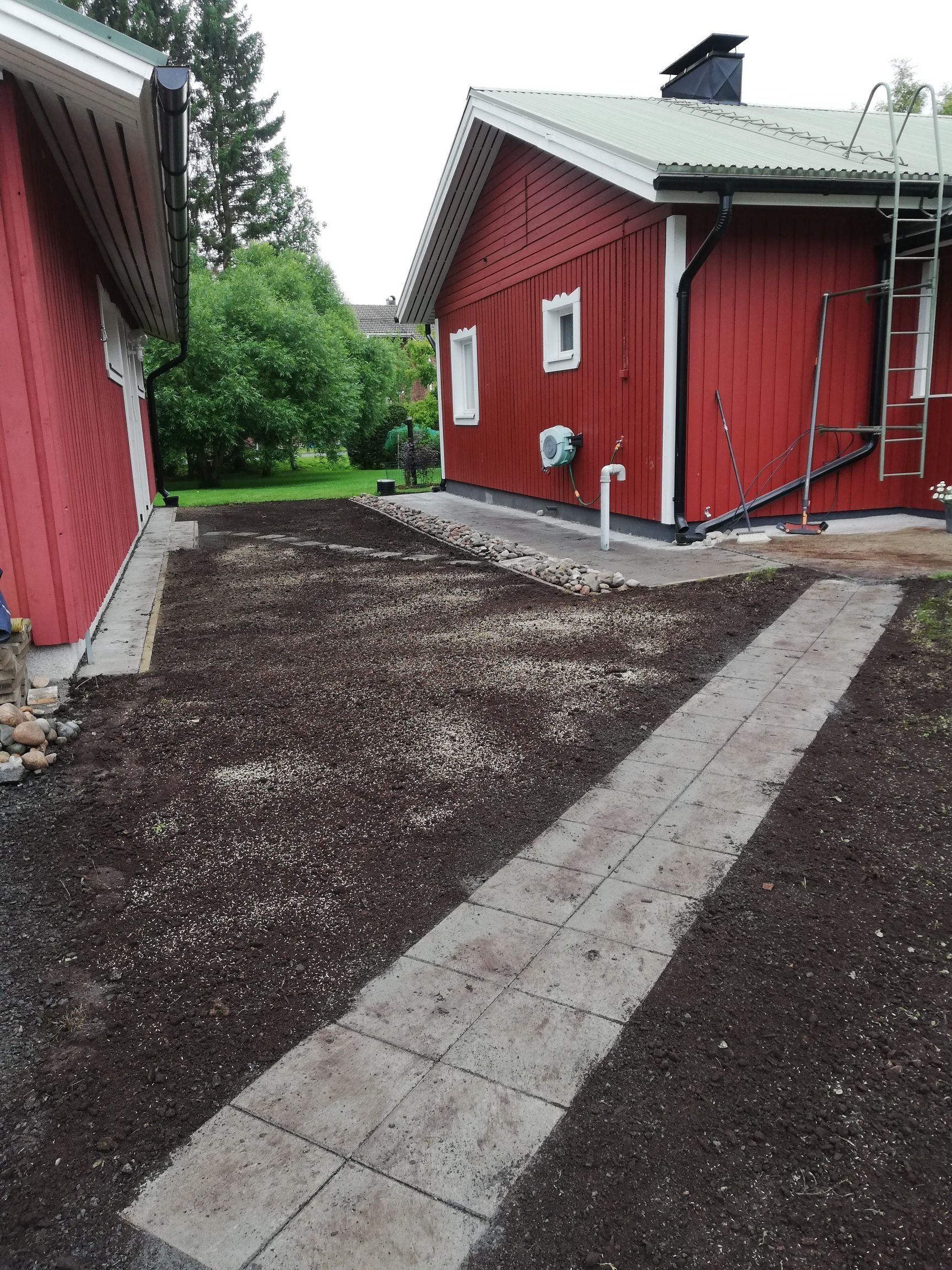 Punaisia rakennuksia, joiden välissä on sorapolku ja taustalla puita