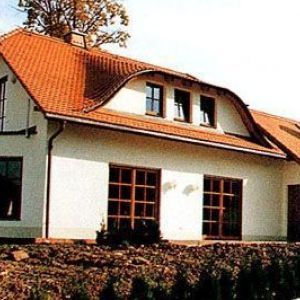 Rückansicht eines modernen Hauses mit großer Fensterfront und Terrasse.