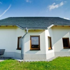 Nahaufnahme von Dachrinne und dunkler Dacheindeckung.