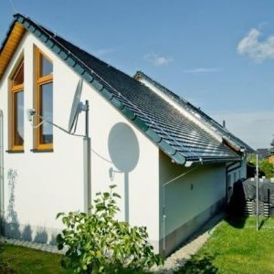 Detail von Dachschräge, Solarpanel und Giebelfenster.