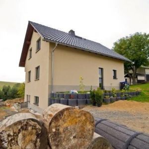 Schlichter Neubau mit grauen Ziegeln und hellem Putz.