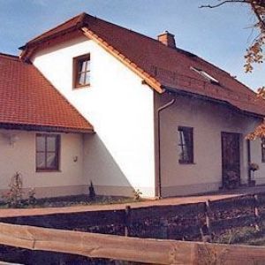 Weißer Giebel mit braunen Dachziegeln und einem kleinen Fenster.