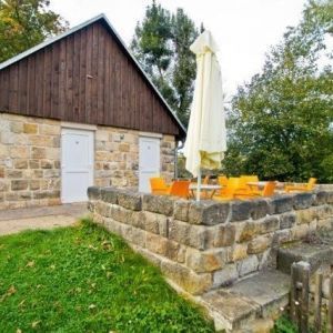Rustikales Steingebäude mit Terrasse und Sonnenschirm