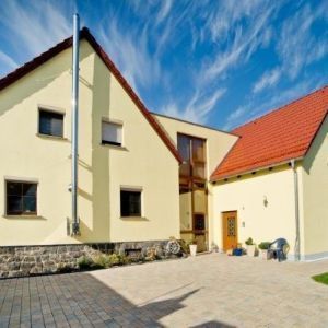 Modernes Wohnhaus mit rotem Dach unter blauem Himmel