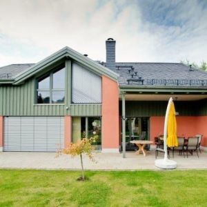 Obergeschoss eines Hauses mit grüner Holzverkleidung und roter Wandfläche.