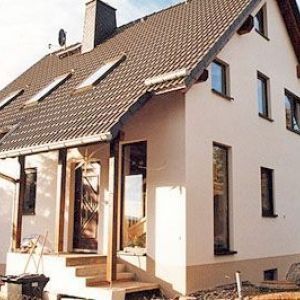 Mehrfamilienhaus mit vielen Dachgauben und Dachfenstern.