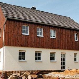 Längliche Scheune oder Bauernhaus mit dunkler Holzverkleidung.