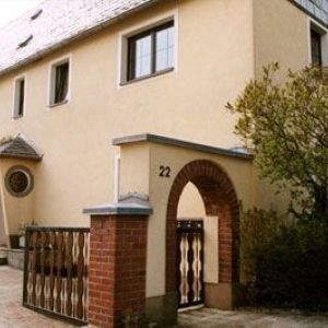 Saniertes Herrenhaus mit grünen Fensterläden und Schieferdach.