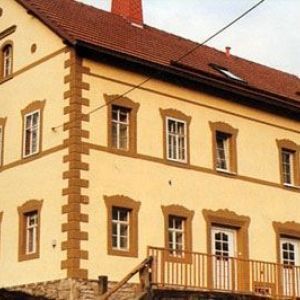 Historische Fassade mit braunen Eckquadern und Gesimsen.