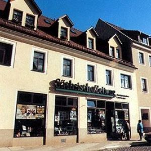 Häuserzeile mit hellen Fassaden und vielen kleinen Dachgauben.