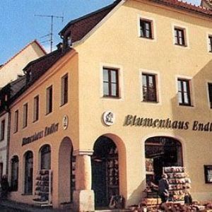 Beiges Stadthaus mit der Aufschrift „Blumenhaus“.