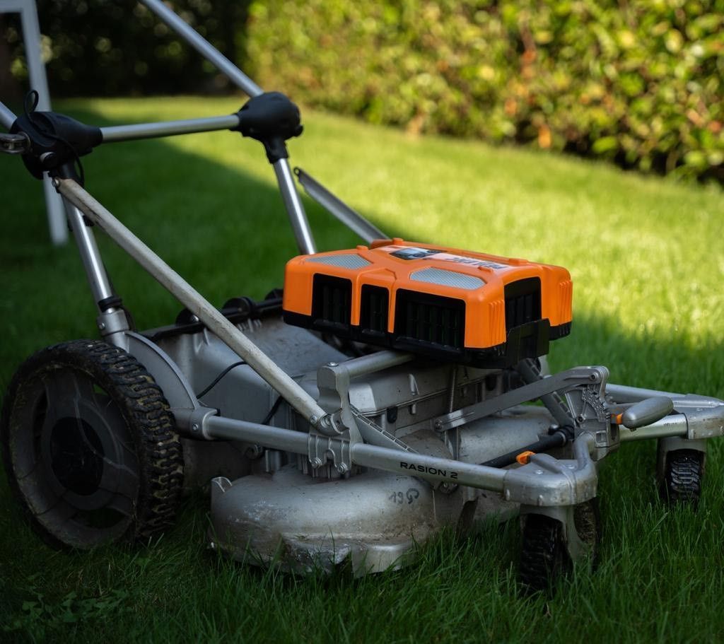 Ein Rasenmäher steht auf einem üppigen grünen Rasen.