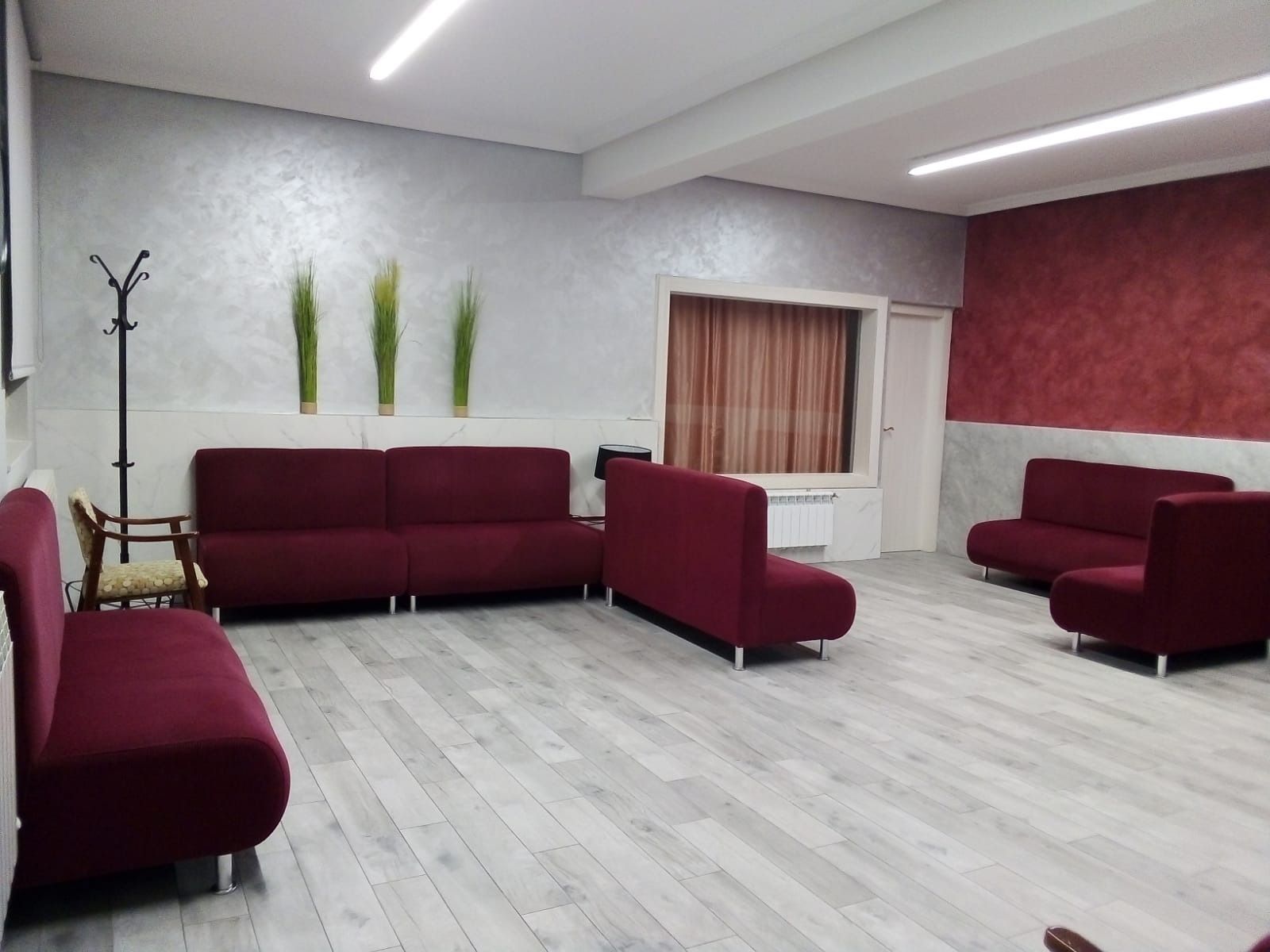 Una habitación con muchos sofás y sillas rojos.