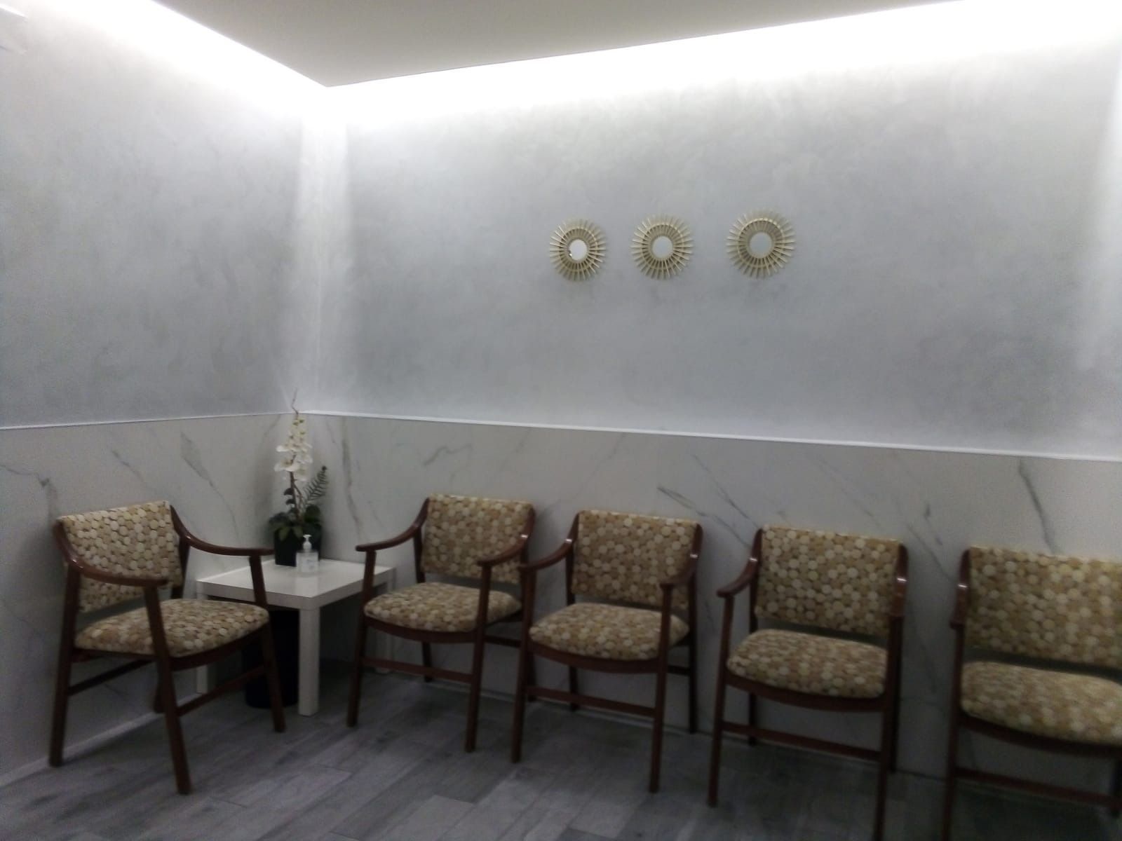 Una sala de espera con cuatro sillas y una mesa