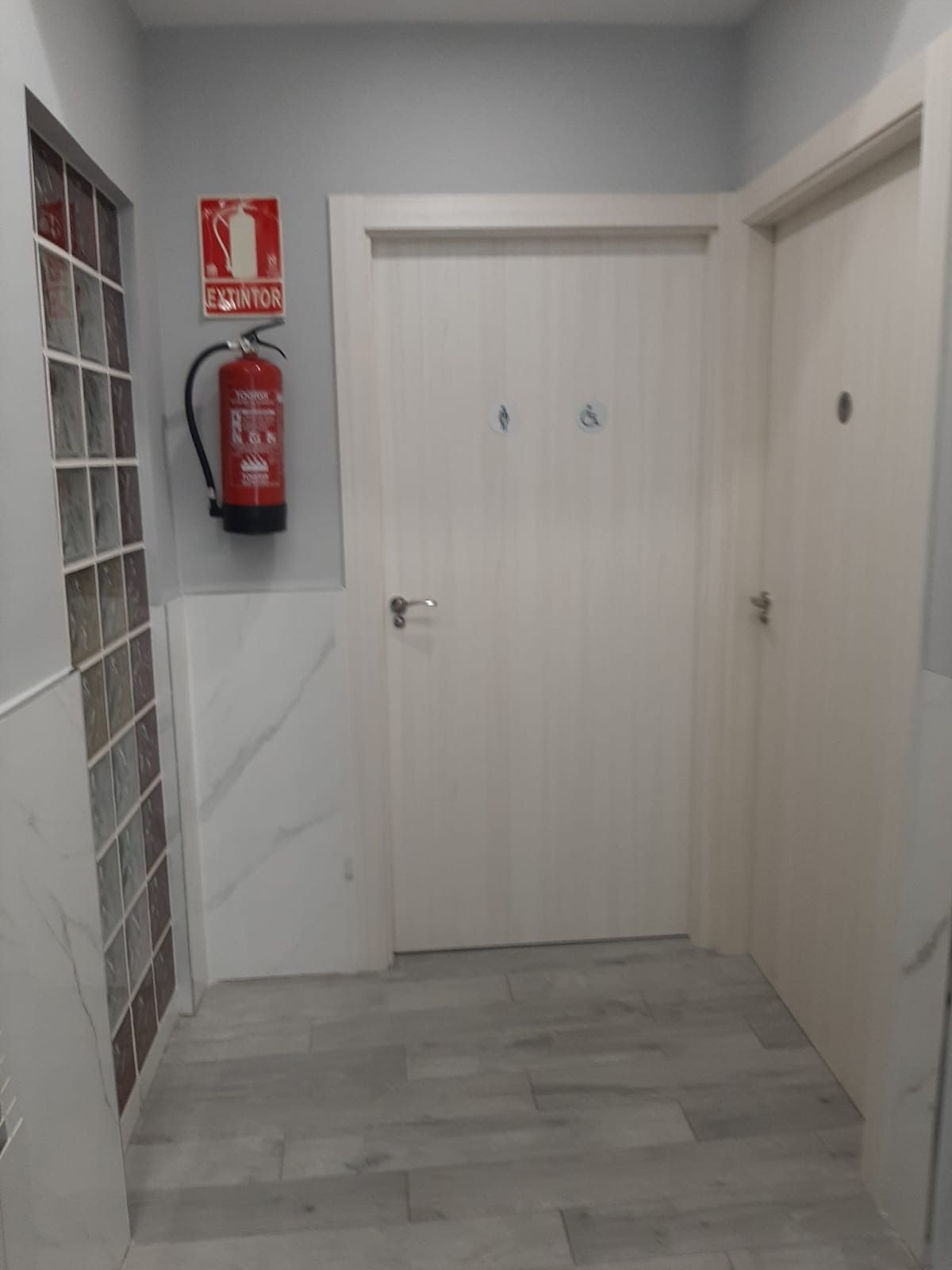 Un pasillo con un extintor colgado en la pared.