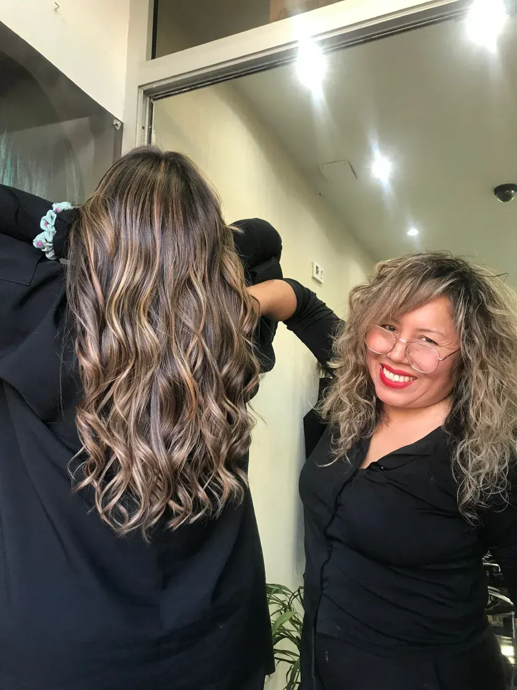 Una cabeza de maniquí exhibe un elaborado peinado rubio rizado adornado con un peine decorativo con detalles de perlas.