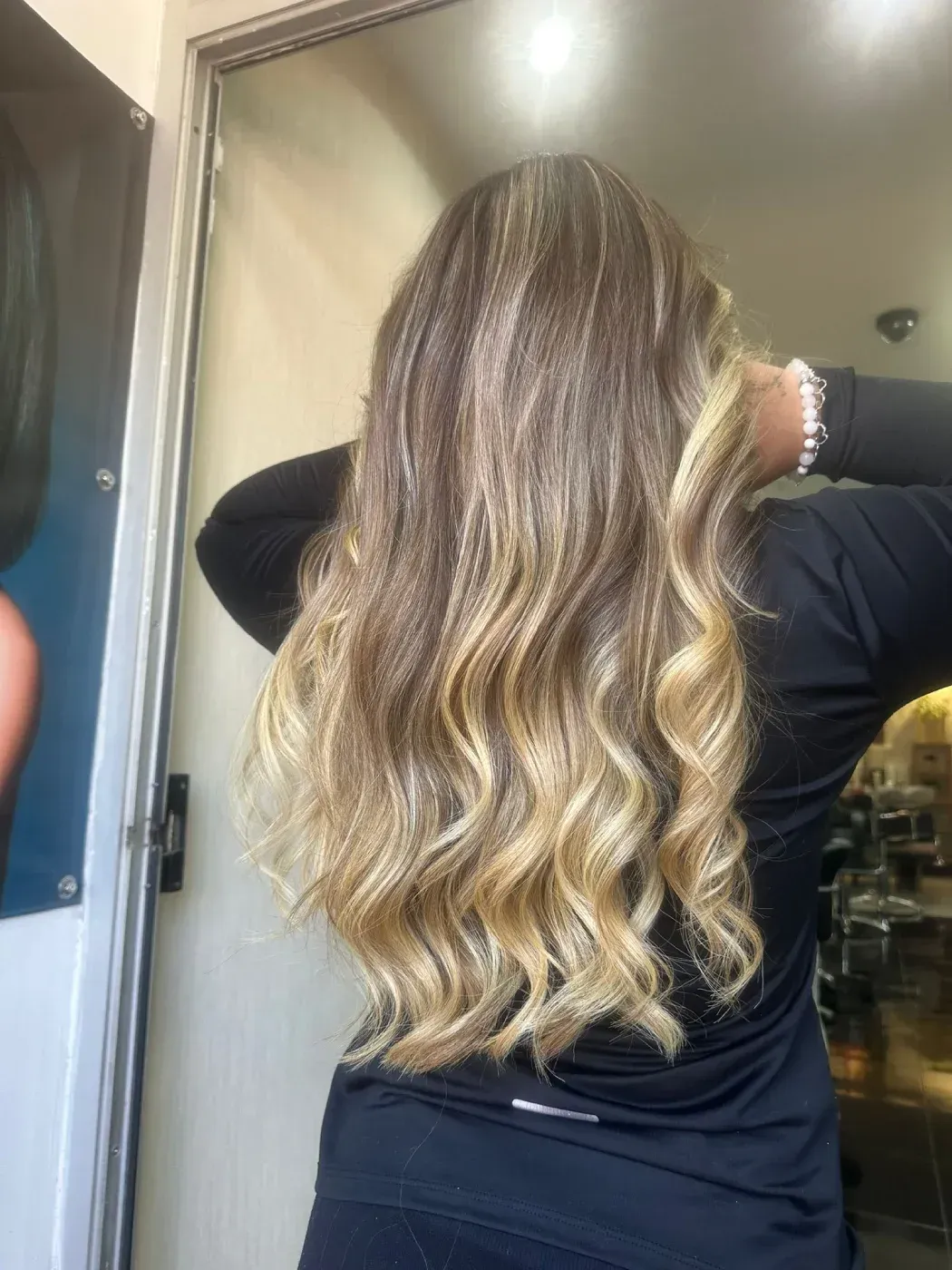 Vista posterior de una cabellera lisa, brillante y de color castaño oscuro en un salón de belleza.