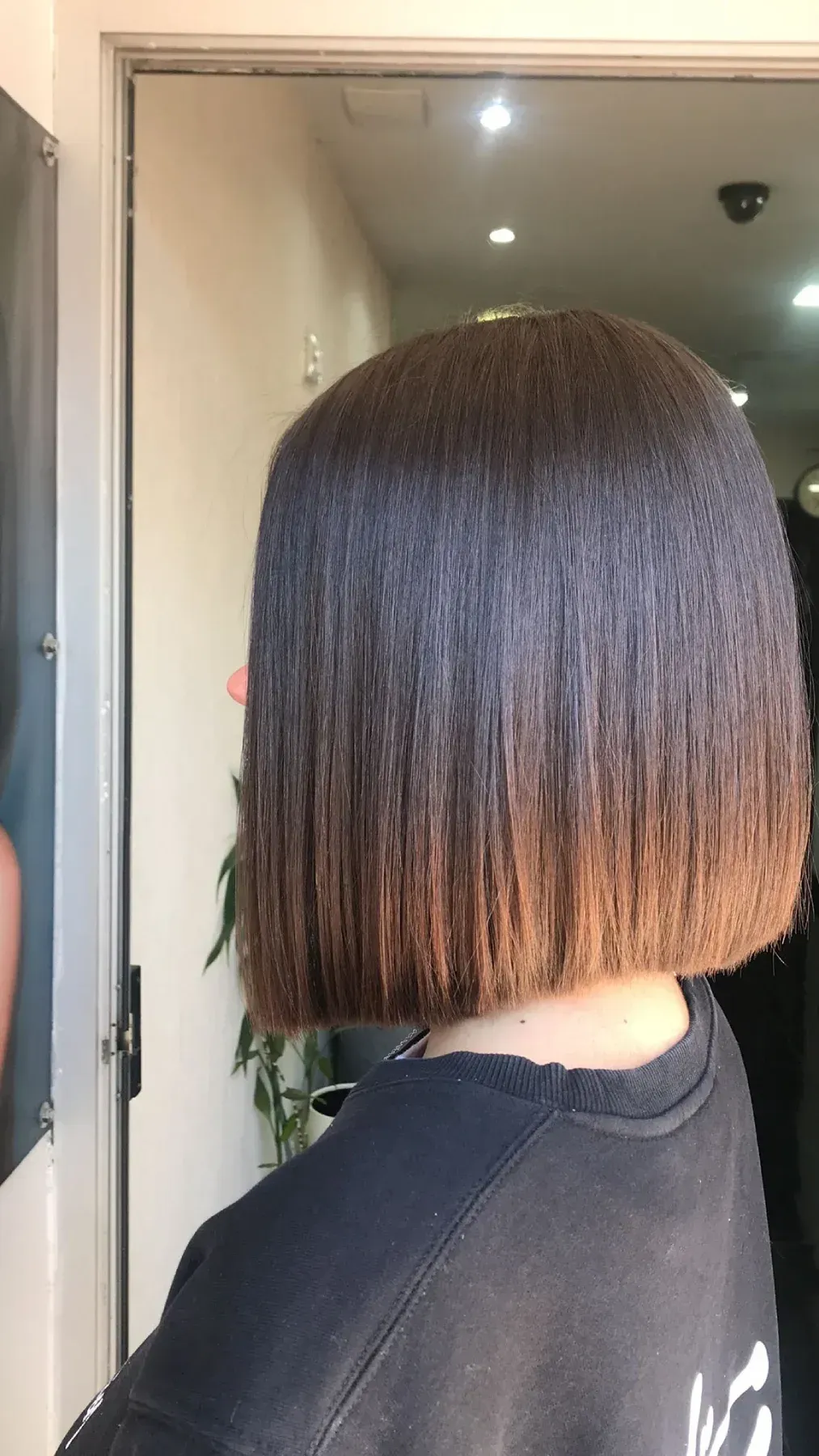 Una persona con cabello largo, voluminoso y rizado de color rojo vibrante, vista desde atrás.