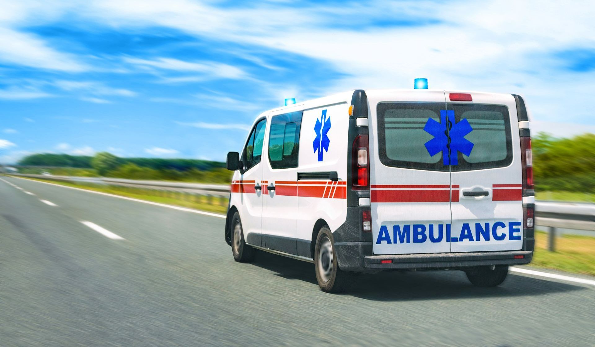 Ambulance, vue de derrière, en train de rouler sur une voie rapide