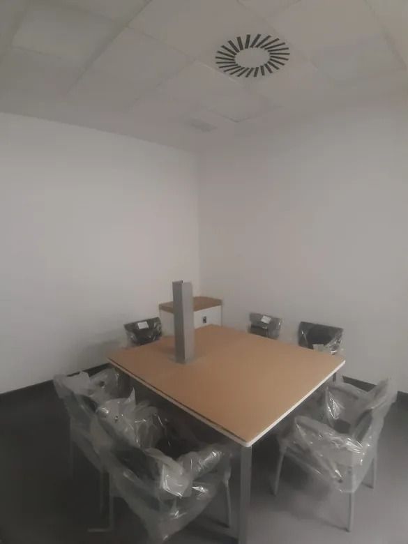 Una sala de conferencias con una mesa y sillas envueltas en plástico.