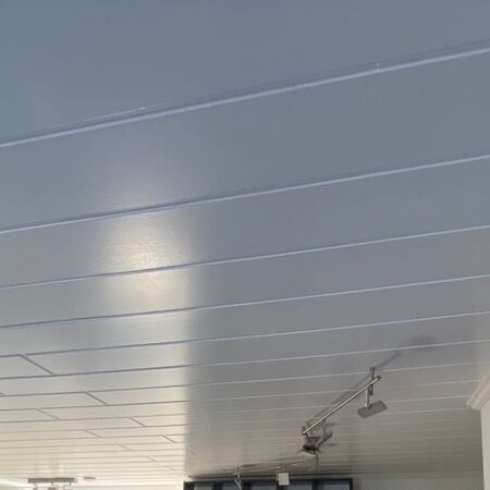 Graue, getäfelte Decke mit Einbauleuchten.