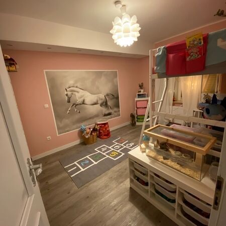 Rosa Schlafzimmer mit Pferde-Wandbild, Etagenbett, Hamsterkäfig und Hüpfspiel-Teppich.