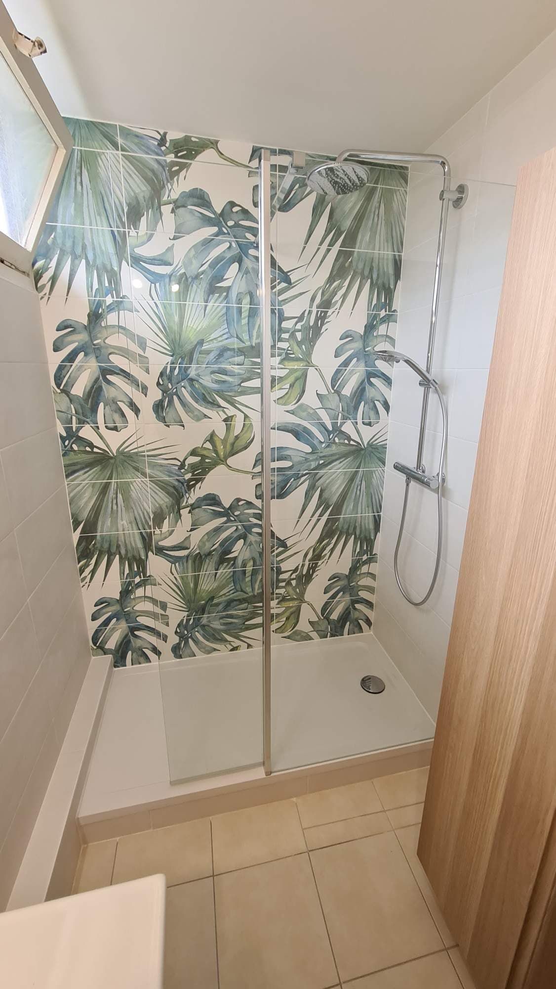 Une douche avec du carrelage décoratif