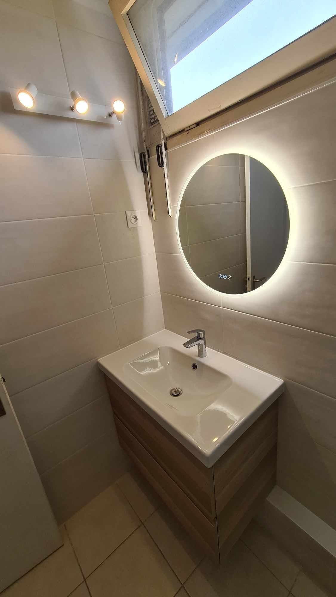Un miroir lumineux avec un meuble vasque