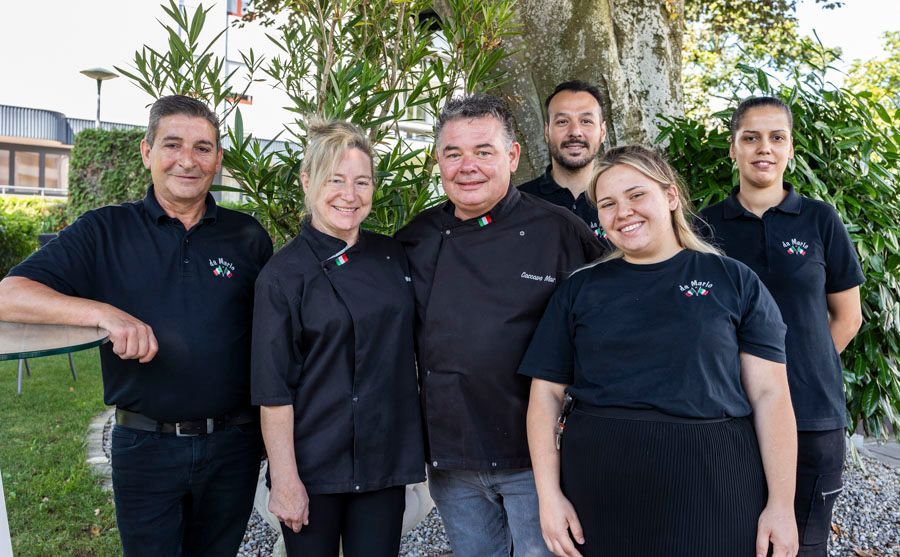 Eine Gruppe von Menschen posiert vor einem Baum für ein Foto.