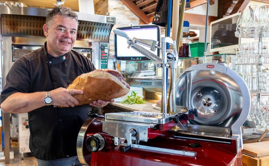 Eine Terrasse mit Tischen und Stühlen vor einem Gebäude.