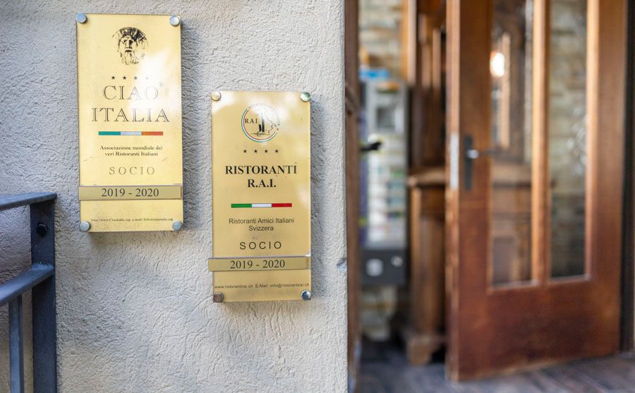 Zwei Schilder an der Seite eines Gebäudes mit der Aufschrift „Ristorante Rai“