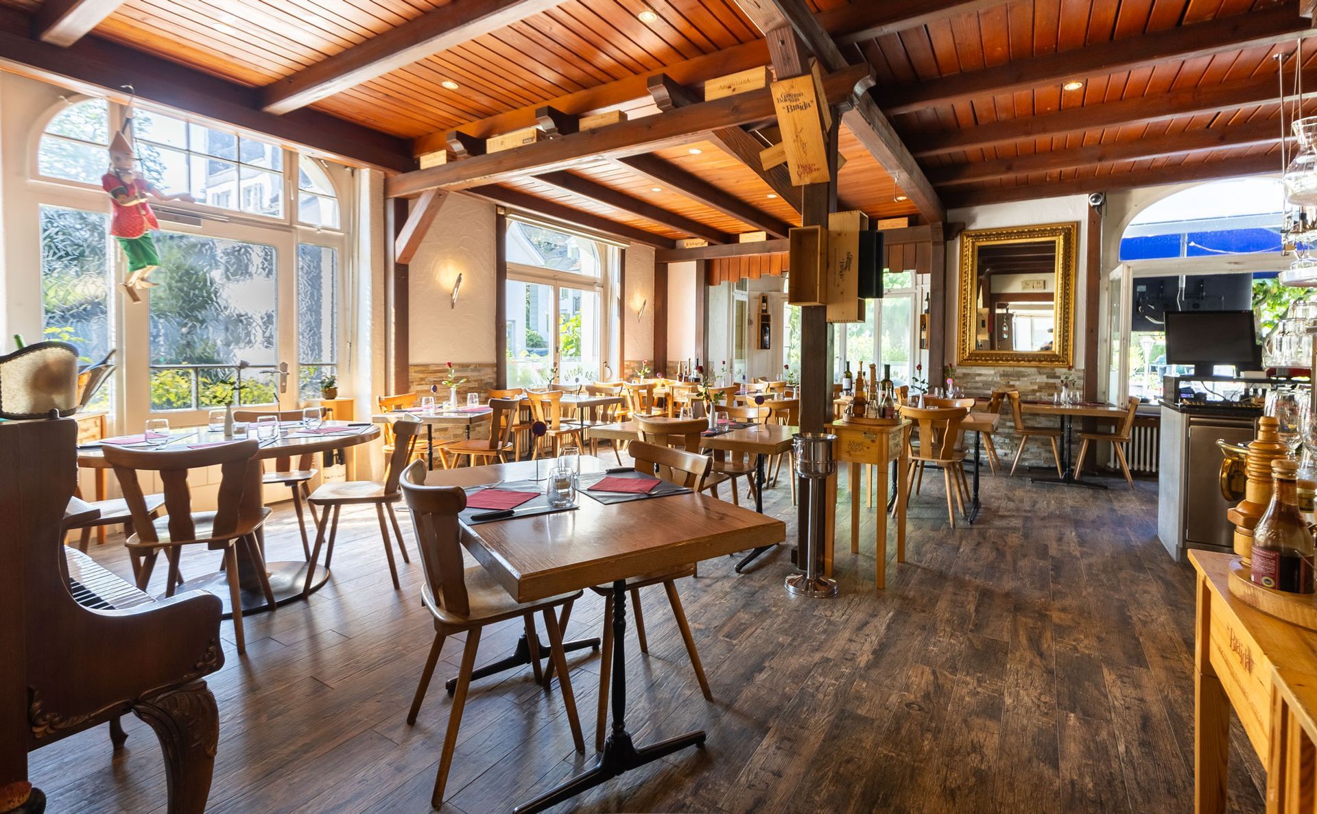 Ein Restaurant mit Tischen und Stühlen und einem großen Gemälde an der Wand.