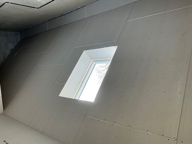 Schräge Decke mit einem kleinen rechteckigen Oberlicht, das Tageslicht hereinlässt.