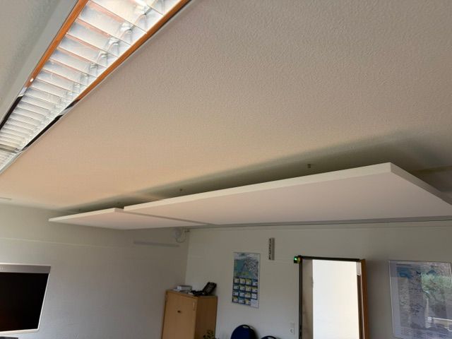 Großes weißes Wandregal oder Aufbewahrungsmöbel in einem Raum mit Dachschräge und Fenster.