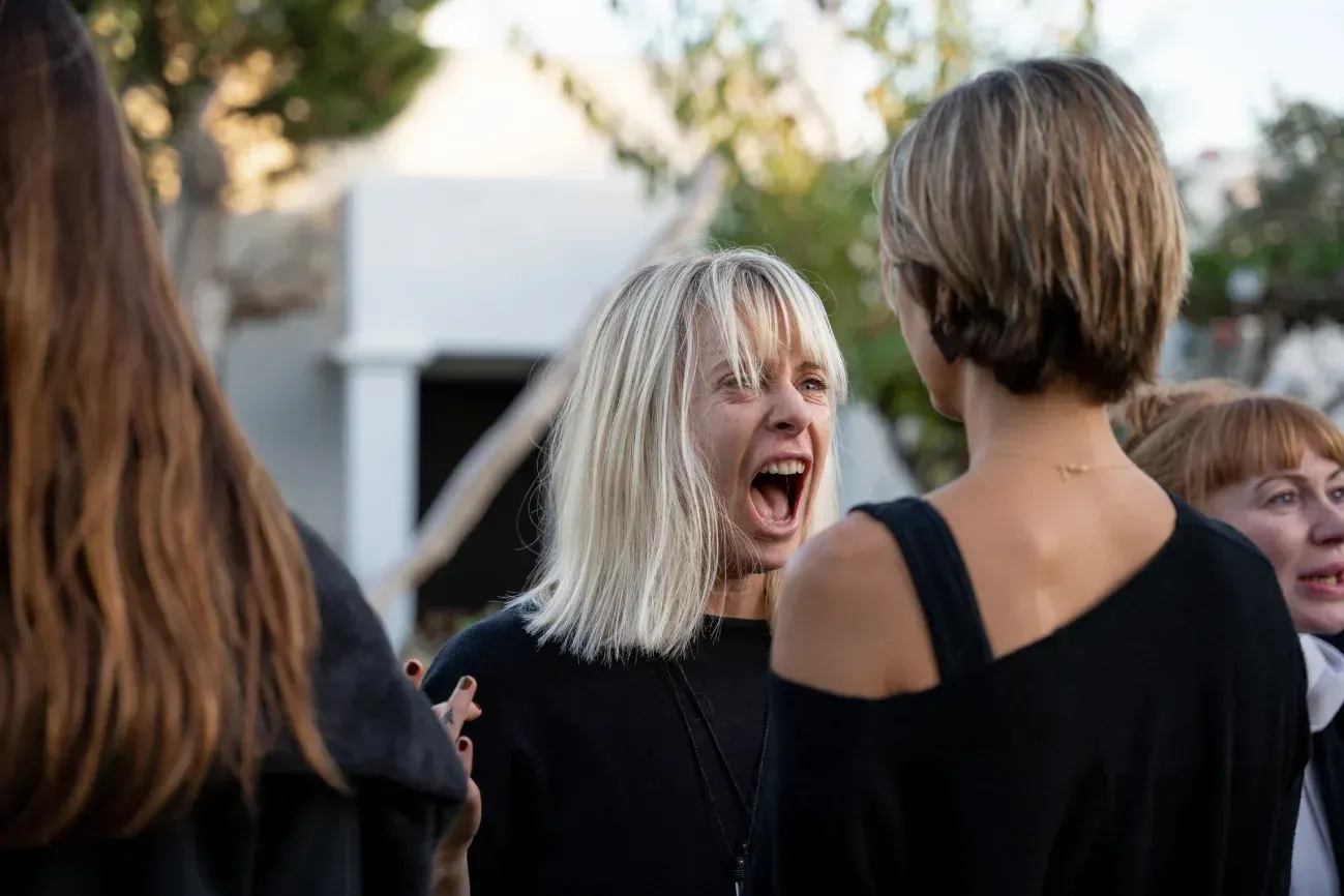 Un grupo de mujeres están paradas una al lado de la otra y ríen.