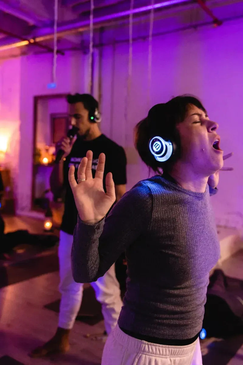 Una mujer está cantando en un micrófono mientras usa auriculares.