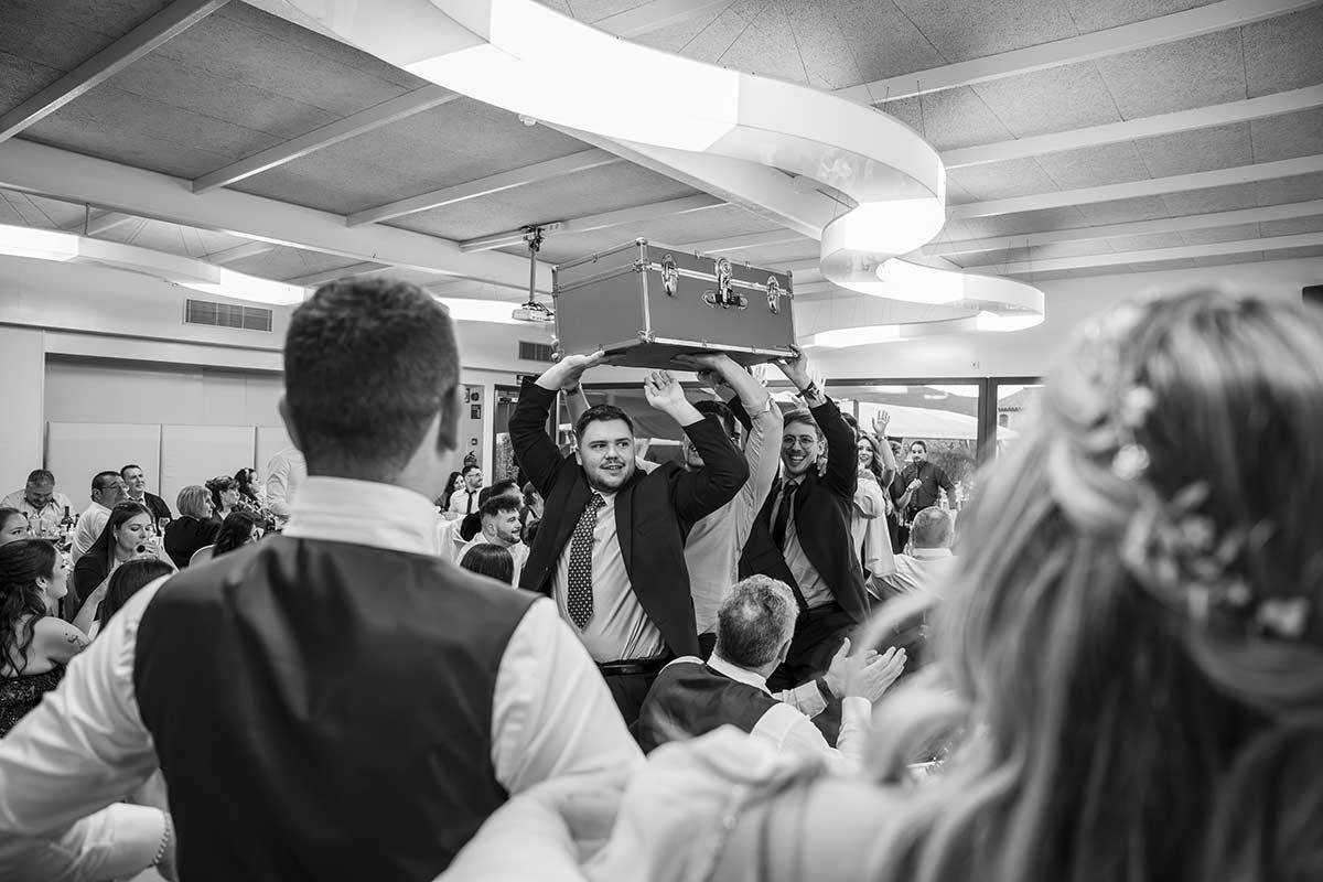 En una fotografía en blanco y negro, un hombre sostiene una maleta sobre su cabeza.