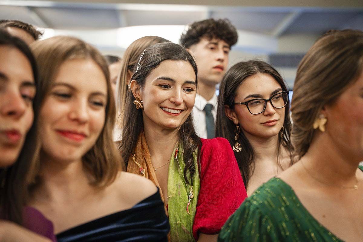Un grupo de mujeres jóvenes están sentadas en fila en una fiesta.