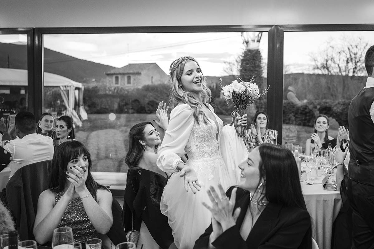 Una fotografía en blanco y negro de una novia bailando en una recepción de boda.