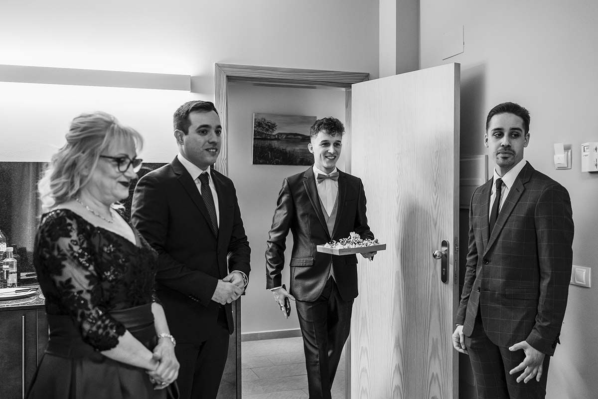 Una fotografía en blanco y negro de un grupo de personas paradas una al lado de la otra en una habitación.