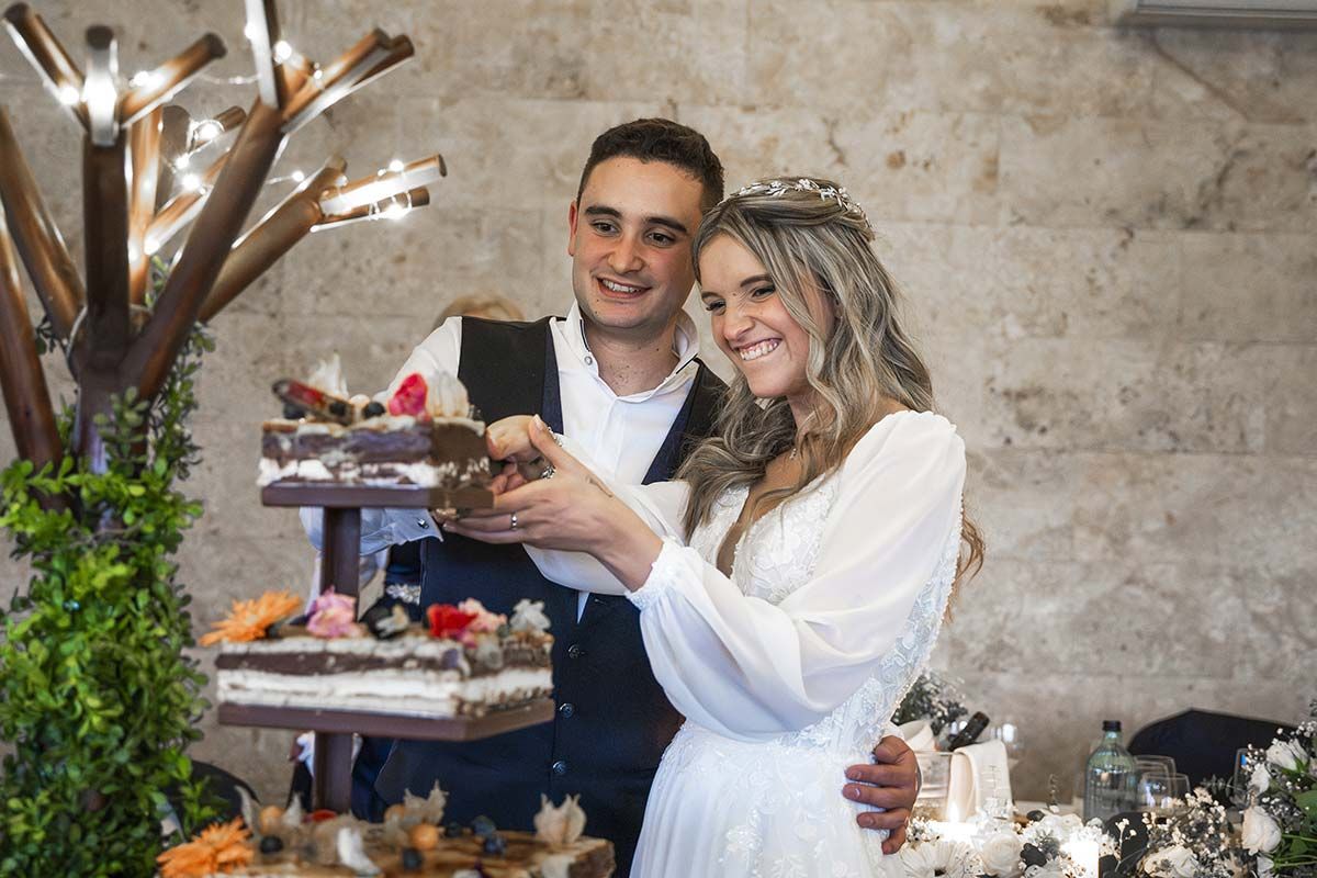Una novia y un novio están cortando su pastel de bodas.