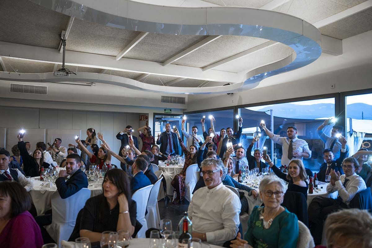 Un grupo grande de personas están sentadas en las mesas de un restaurante.