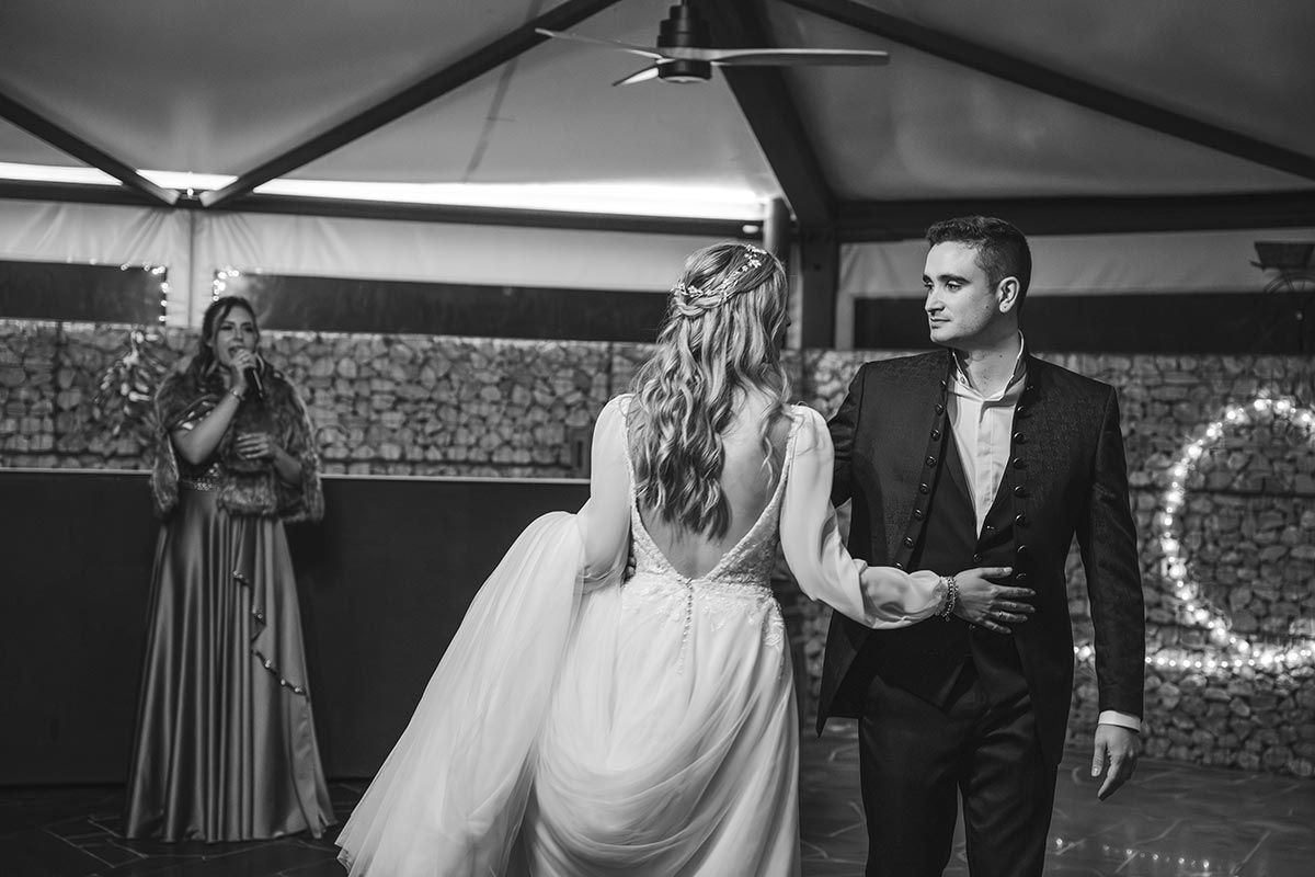 Una fotografía en blanco y negro de una novia y un novio bailando en la recepción de su boda.
