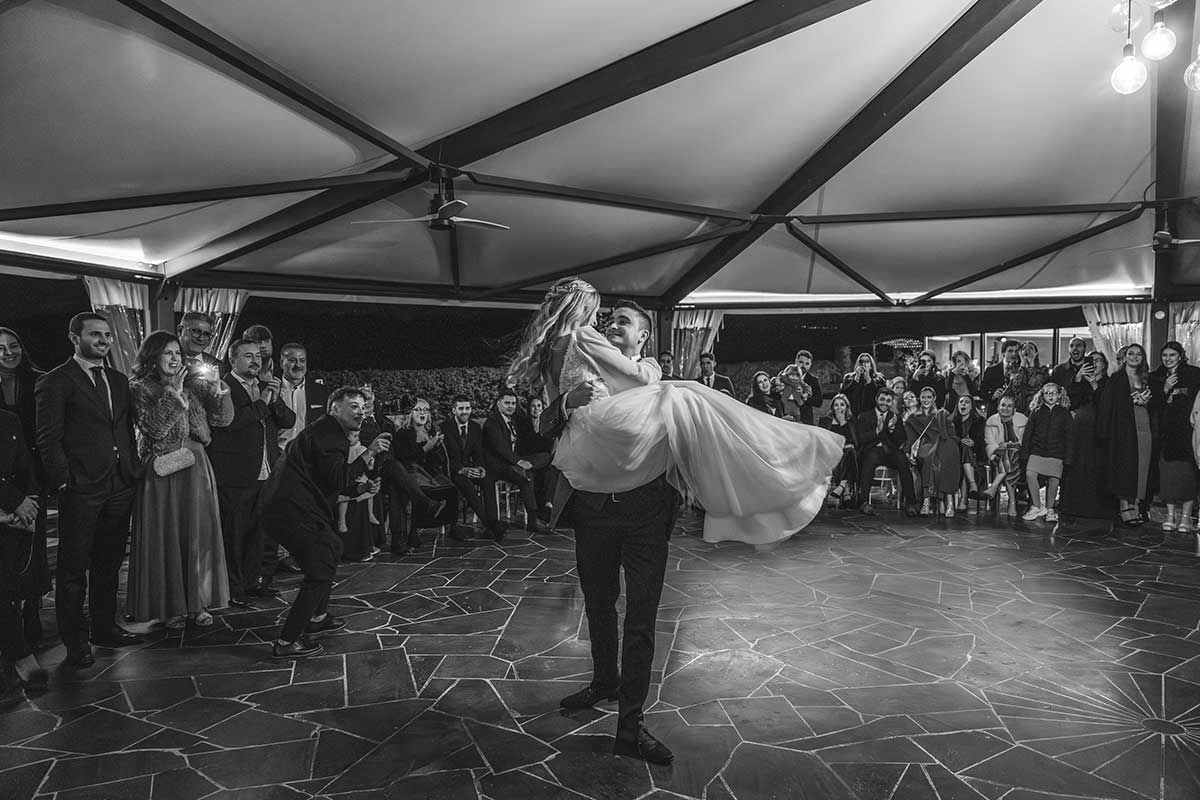Una fotografía en blanco y negro de una novia y un novio bailando en una recepción de boda.