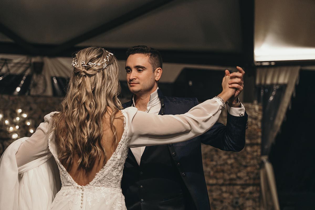 Una novia y un novio están bailando juntos en la recepción de su boda.