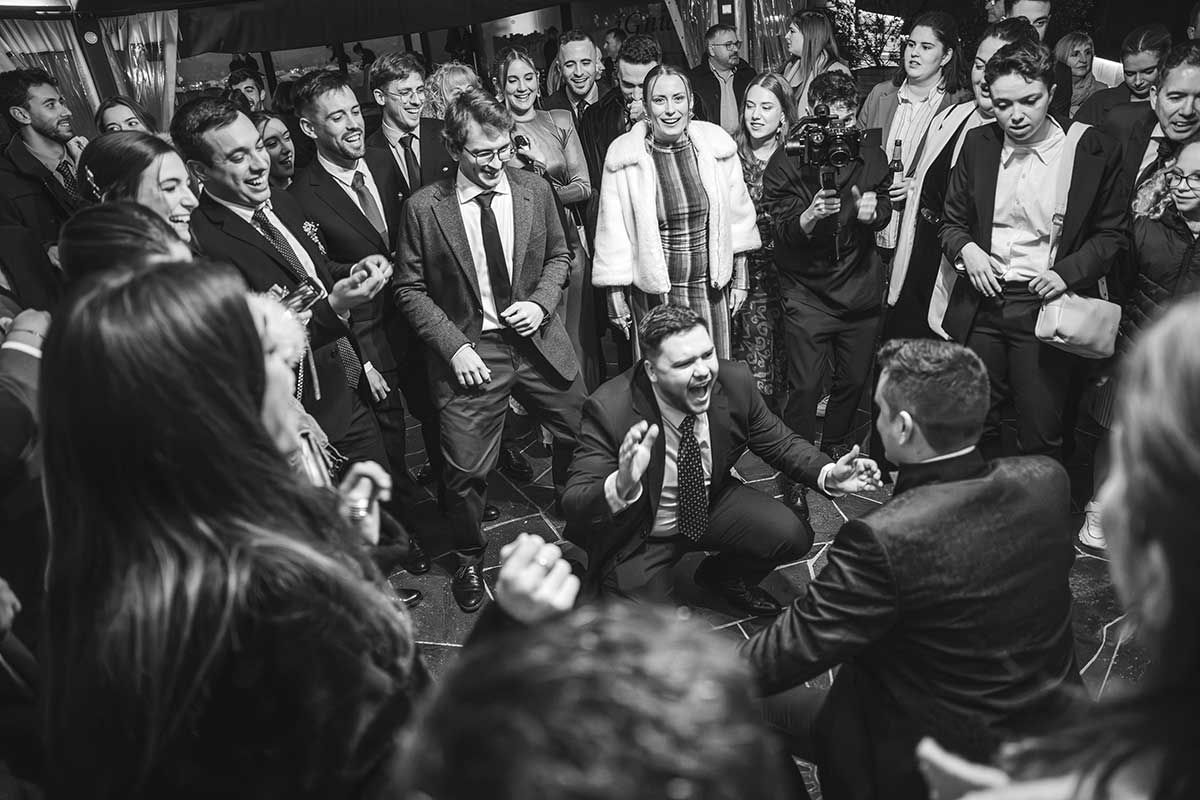 Una fotografía en blanco y negro de una multitud de personas bailando en una fiesta.