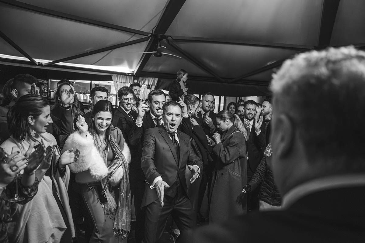 Un hombre con traje está parado frente a una multitud de personas.