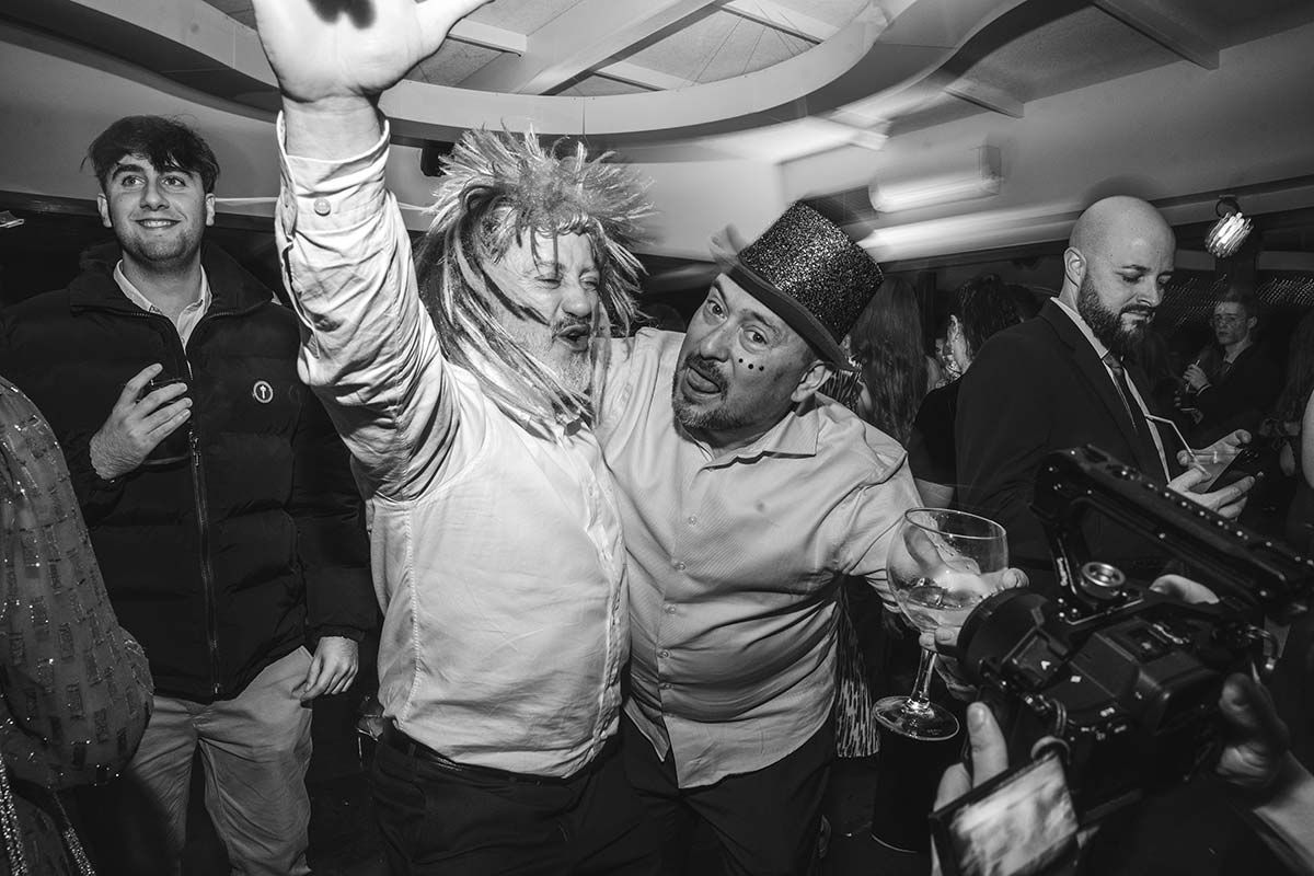 Una fotografía en blanco y negro de dos hombres bailando en una fiesta.